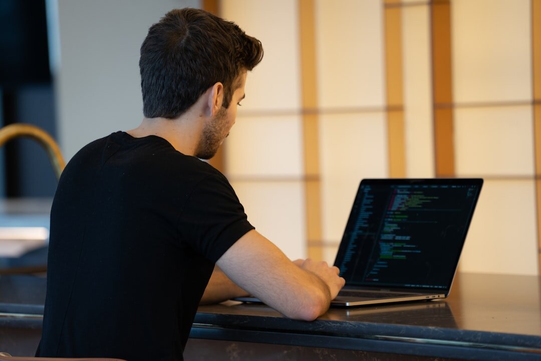 web developer coding on laptop